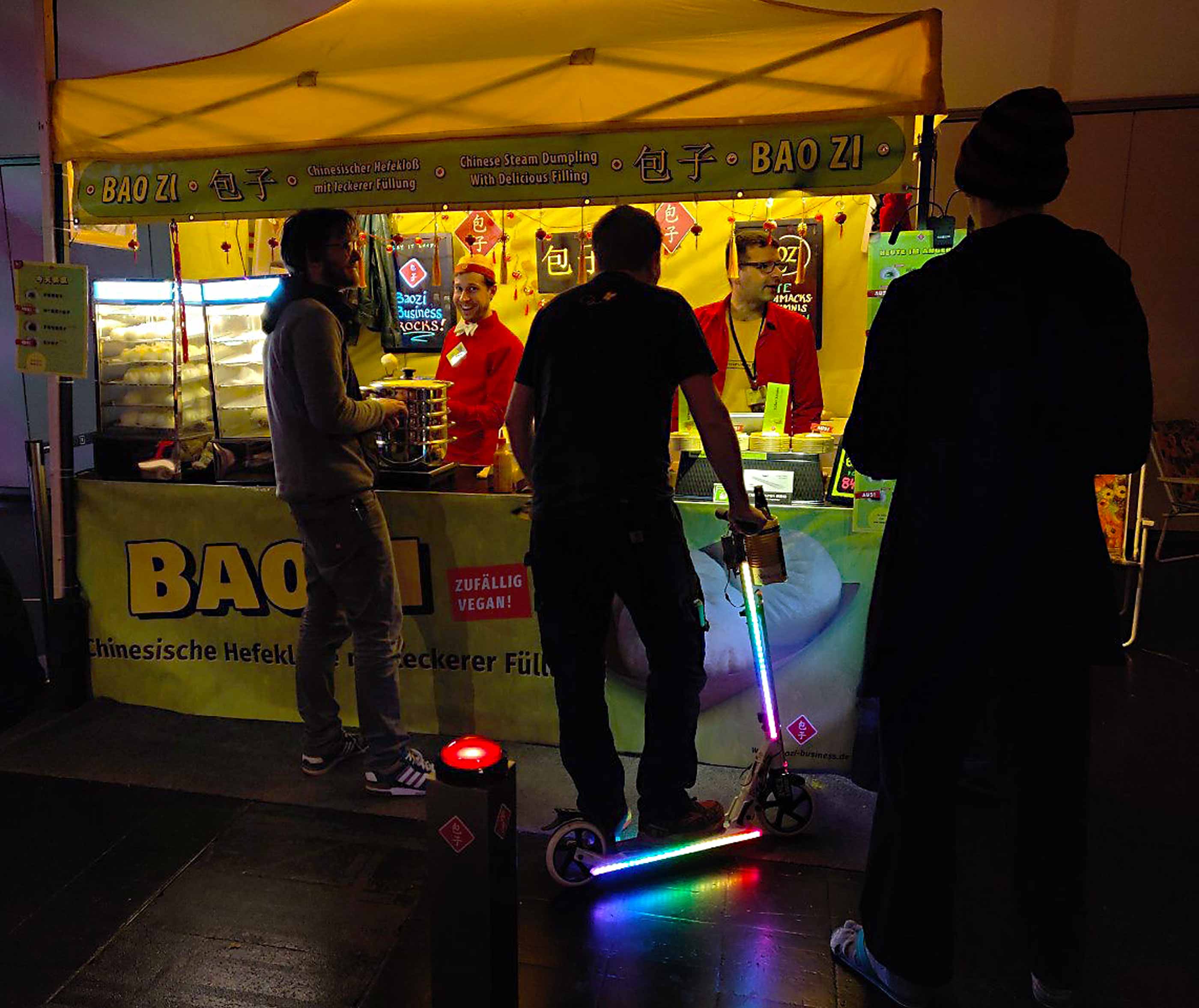 Gäste vorm Baozi-Stand, cool beleuchtet.